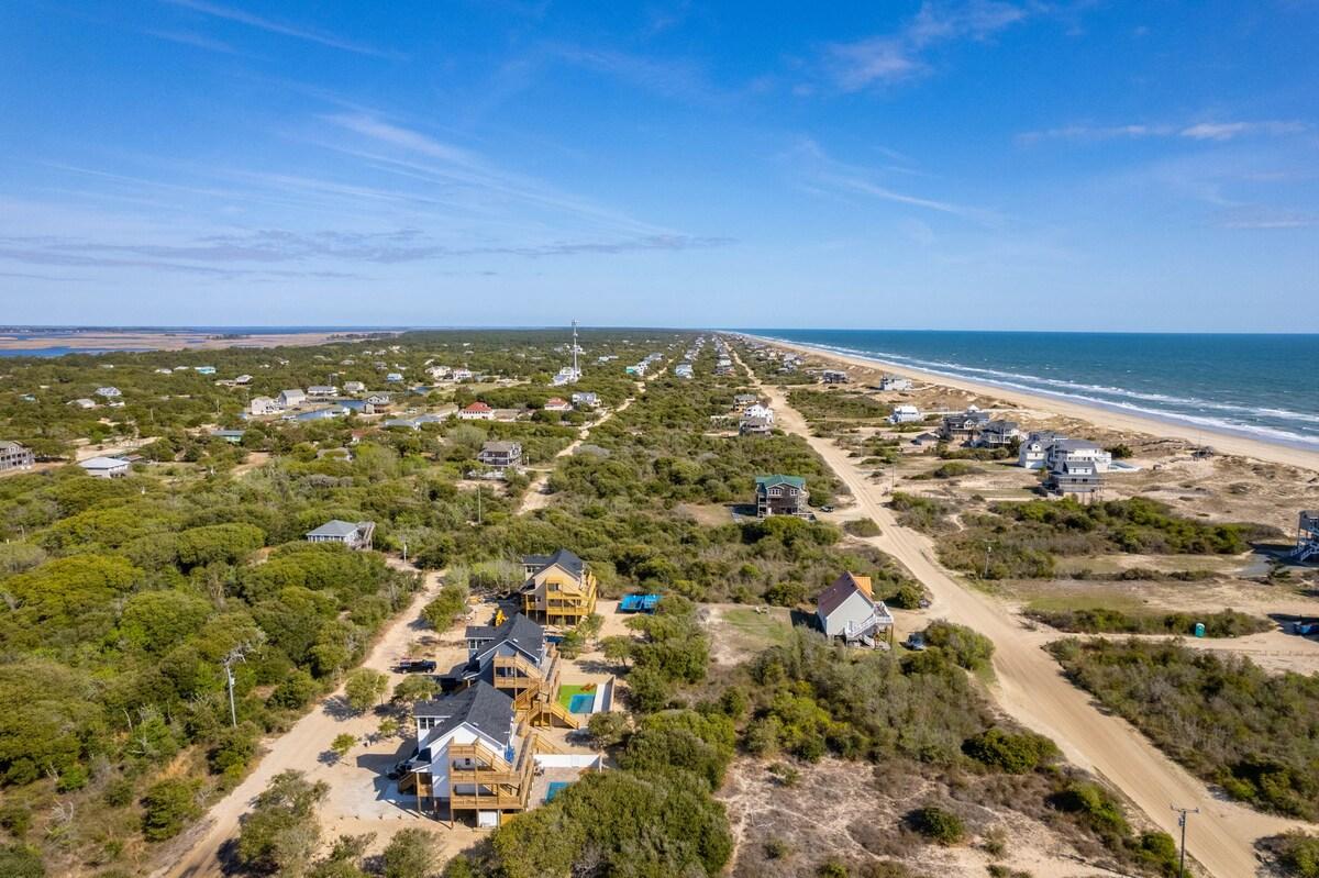Aerial of the Carova strip: sand roads, scattered houses and the open beach running north