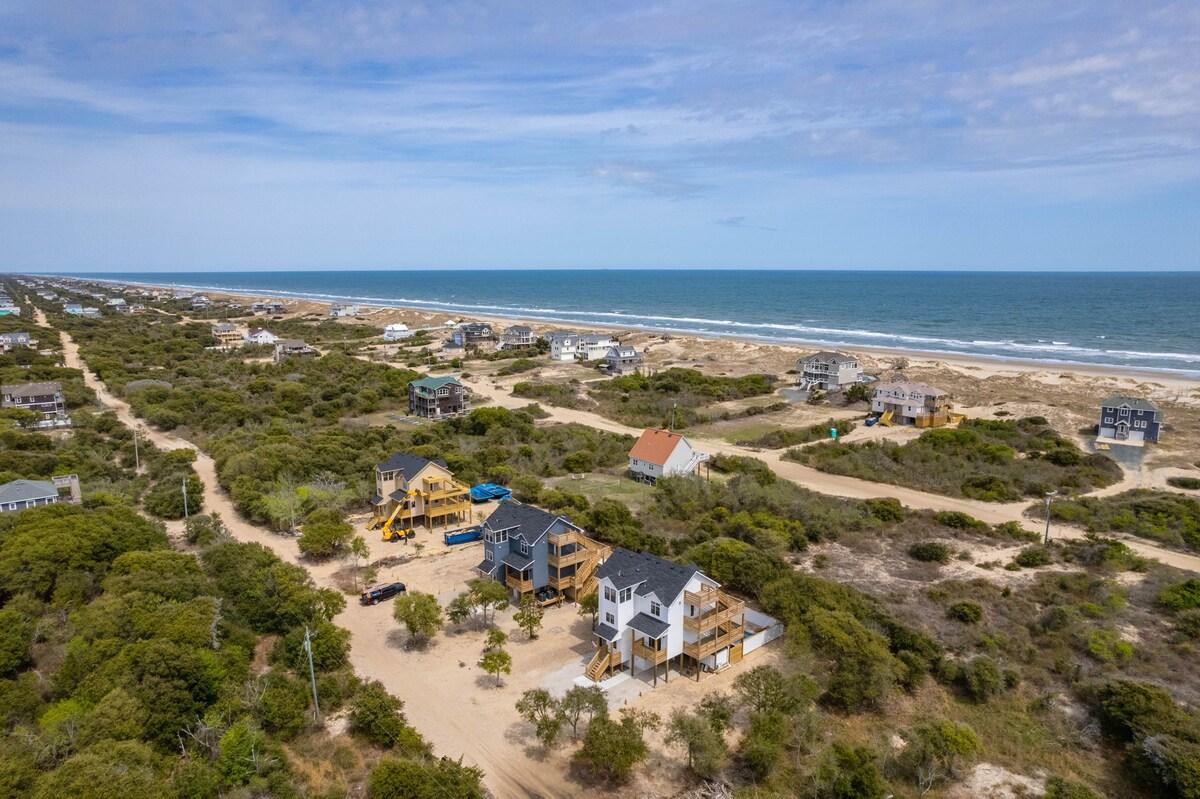 Aerial at dusk over the dunes and houses of Carova