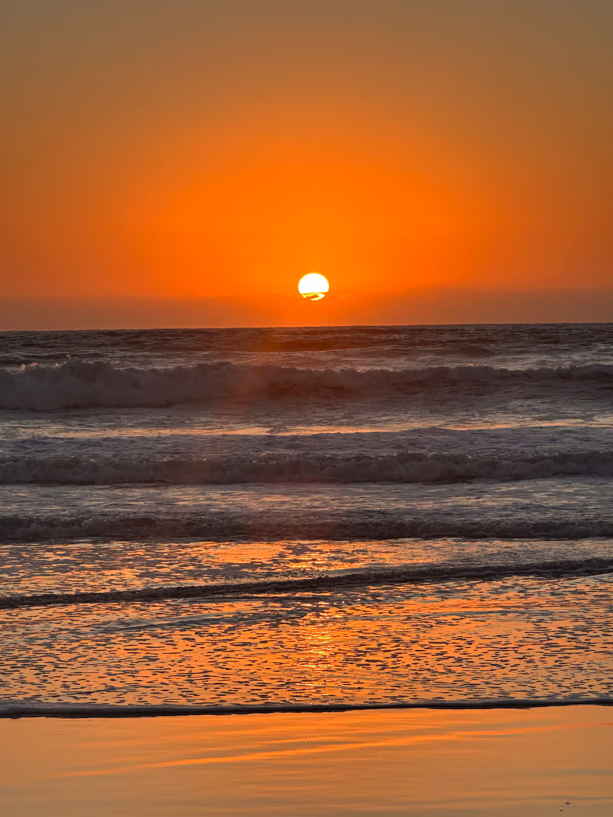 Low orange sun over the surf