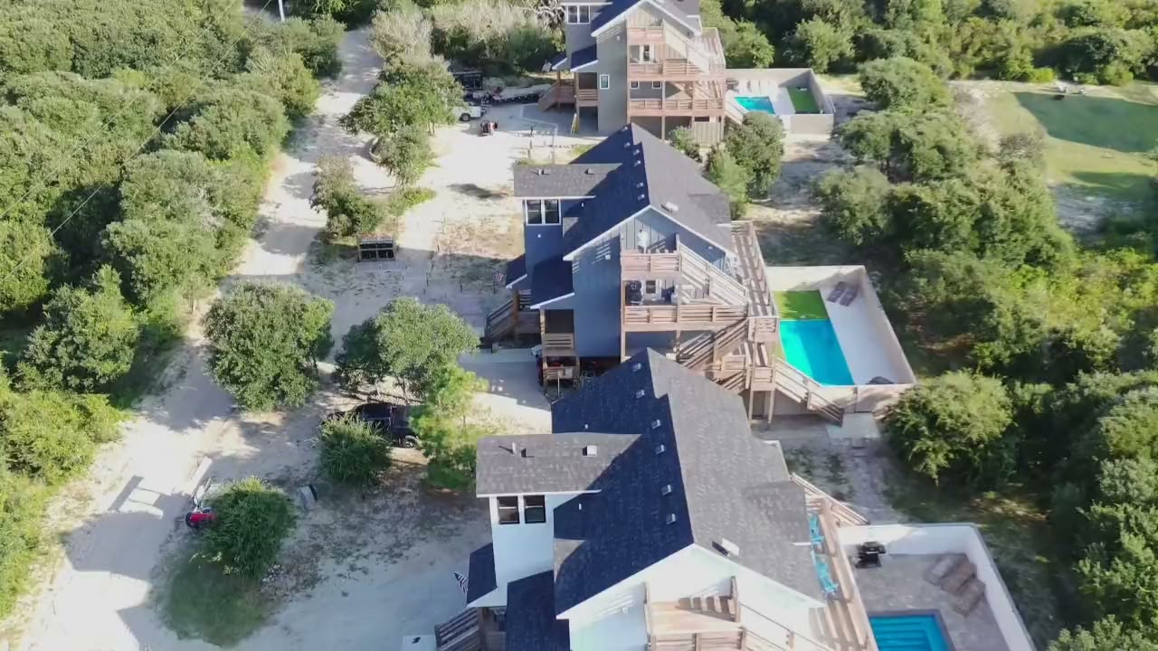 Aerial orbit over all three homes, each with its own private pool